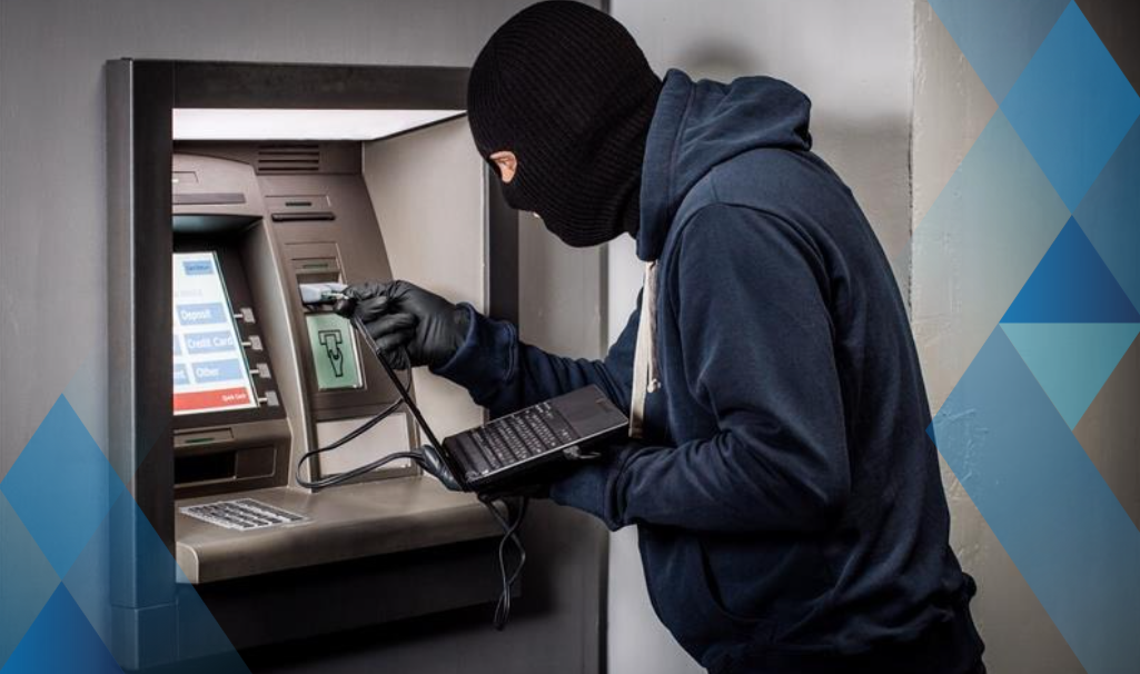 criminal with laptop breaking into ATM
