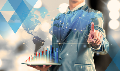 man holding digital bar graph, pointing at a hi-tech looking global map